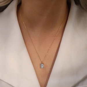 Elegant gold S925 silver necklace with emerald-cut zircon pendant worn by a model