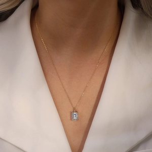 Macro detail of emerald-cut zircon pendant on s925 silver chain worn on neckline