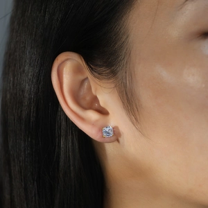 Detailed view of square princess cut zirconia earring in gold setting on model ear