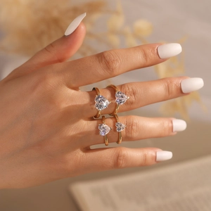 Close-up of four S925 sterling silver heart-shaped zircon rings on a hand