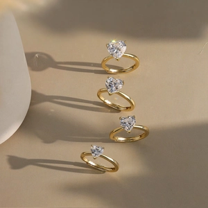 Set of four adjustable golden rings with heart-shaped zircon stones in polished finish