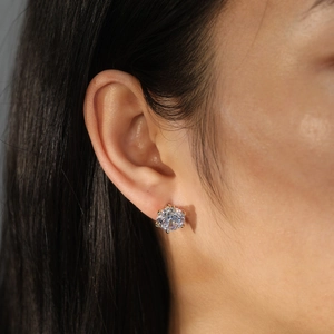 Detail of classic crown setting on gold cubic zirconia stud earrings worn by a model