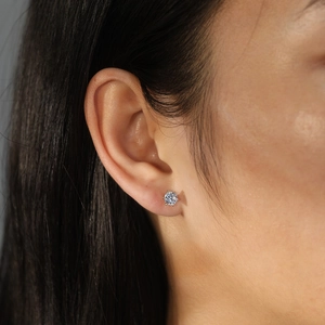 Classic round brilliant-cut solitaire stud earring with six-prong setting on female model