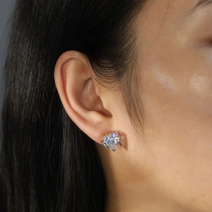Vue macro d'une boucle d'oreille cœur en zircone sur modèle avec serti griffe doré