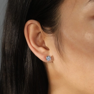 Classic six-prong gold stud earring with sparkling round zircon on model ear