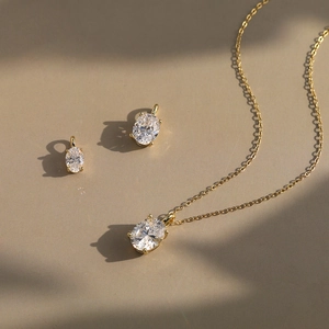 Golden minimalist chain necklace with oval white gemstone pendant in a classic claw setting