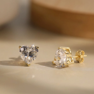 Gros plan de boucles d'oreilles cœur en or 18K avec zircon 8A et fermoir papillon