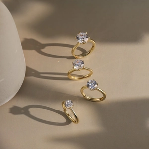 Detailed view of four gold moissanite rings with prong setting and adjustable band