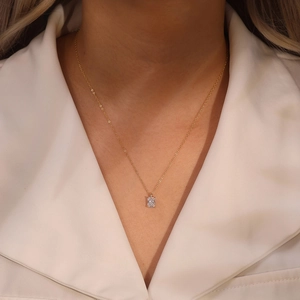 Close-up of women's gold necklace featuring a rectangular emerald-cut zircon pendant