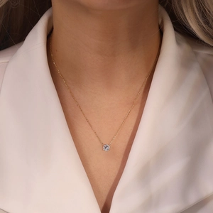 Close-up of minimalist S925 silver gold-plated necklace with a sparkling cubic zirconia pendant