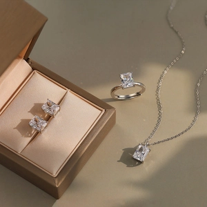 Elegant silver jewelry set with emerald-cut zircon necklace, open ring, and stud earrings