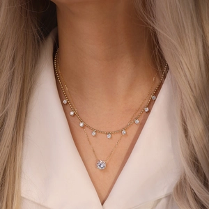 Close-up of a layered gold S925 sterling silver necklace featuring brilliant zircon stones