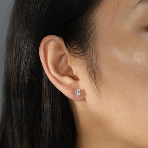 Close-up of model wearing an oval-cut 4 carat zircon stud earring in silver setting