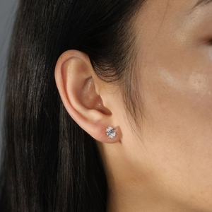 Close-up of elegant gold oval-cut cubic zirconia stud earrings with claw setting