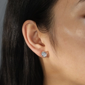 Detail of 4-carat oval-cut zircon earring on ear with elegant gold claw setting