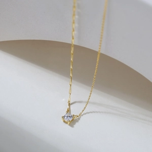 Detailed close-up of golden S925 silver necklace featuring a sparkling zircon pendant