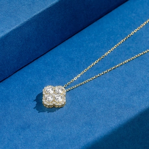 Detail of clover pendant with 8A cubic zirconia on dark blue geometric background