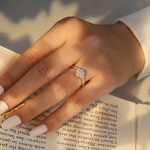 Golden clover ring with micro-paved sparkling crystals on a model's hand with natural light