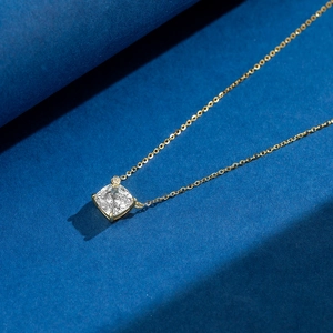Macro detail of S925 sterling silver necklace with cushion-cut zircon and gold chain