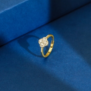 Detailed view of a gold clover ring with pavé crystals and beaded edge on blue velvet
