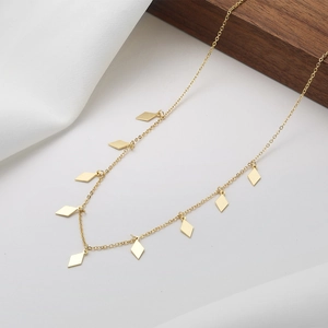 Minimalist gold necklace with geometric rhombus pendants on a thin chain over white surface