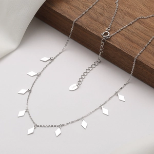 S925 sterling silver necklace with sparkling diamond pendants on a wooden display