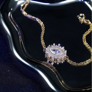 Detail of adjustable evil eye bracelet with marquise stone and gold plating on dark background
