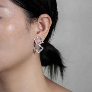 Detail of silver geometric square earrings with sparkling pavé-set zircons on ear