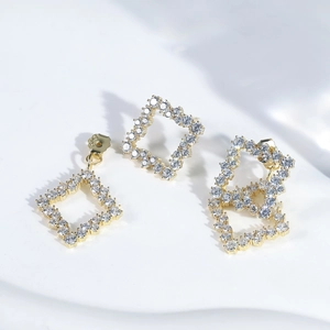 Detailed close-up of S925 sterling silver stamp on golden square zircon stud earrings
