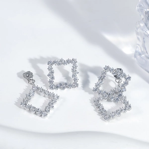 Detailed view of silver square geometric stud earrings with pave-set zircon stones