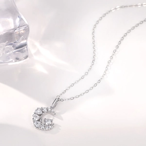 Macro detail of crescent moon pendant necklace with cubic zirconia stones on silver chain