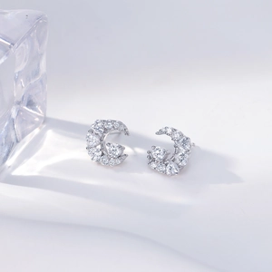 Sparkling silver crescent moon stud earrings with zircon stones on soft white background