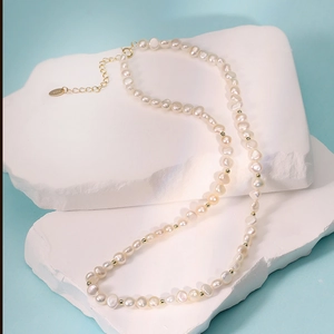 Collier en perles de culture baroques avec perles dorées sur fond bleu élégant