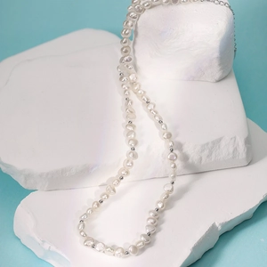 Collier élégant en perles d'eau douce baroque français sur une pierre blanche texturée