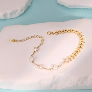 Detail of 925 silver wheat leaf bracelet with pearls and lobster clasp on stone
