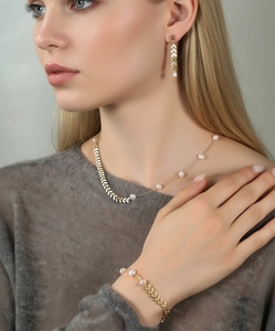 Detail of elegant gold wheat leaf necklace set with lustrous white freshwater pearls