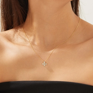 Collier trèfle doré élégant avec zircons porté par un mannequin pour un look de luxe