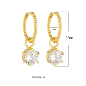 Detailed view of gold hoop earrings with twisted texture and round cz stone pendant