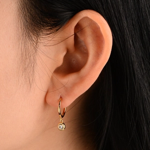 Elegant 925 silver drop earrings in gold with round cubic zirconia on a model