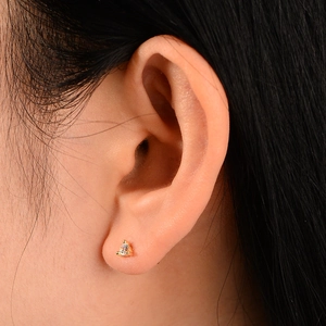 Close-up of minimalist 925 sterling silver stud earring with sparkling gold cubic zirconia