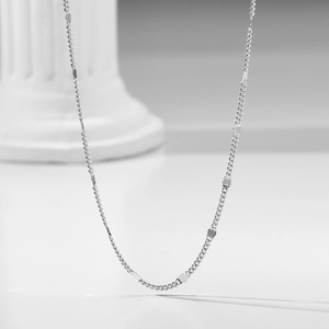 Minimalist S925 sterling silver chain necklace with square plates on a white column pedestal