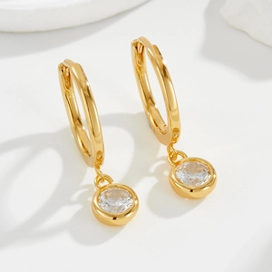 Macro shot of 925 sterling silver gold drop earrings with round bezel-set zircon stones
