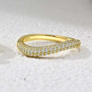 Macro shot of S925 sterling silver gold ring with pavé-set zircons on wavy band