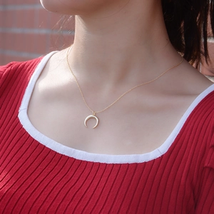 Collier croissant de lune en argent S925 doré porté sur un pull en maille rouge