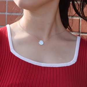 Minimalist S925 sterling silver hammered coin necklace with gold chain worn by a model