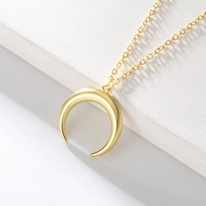Vue macro du pendentif demi-lune doré avec des détails de chaîne fine et polie