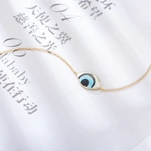 Bracelet classique plaqué or 14 carats avec œil protecteur en émail bleu sur fond de magazine