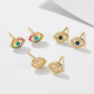 Close-up of gold evil eye stud earrings set with colorful zircon and turquoise stones