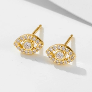 Detailed macro view of 925 silver evil eye studs with micro-pave gold finish and cubic zirconia