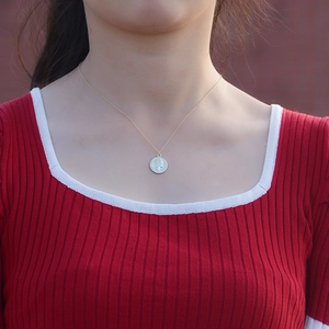 Collier médaille vintage argent S925 doré avec relief reine sur pull en maille rouge